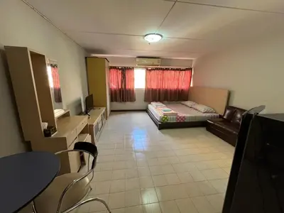 a room with a bed and a table and chairs at Impact Arena C9 by Jintana in Thung Si Kan