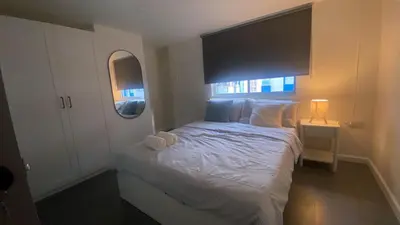 a bedroom with a white bed with a large window at Sawasdee Bangkok Condo Modern 2BR BTS Srinakarin38 connect Sukhumvit Route 20mins Aiport and 15mins Sukhumvit Line in Bangna