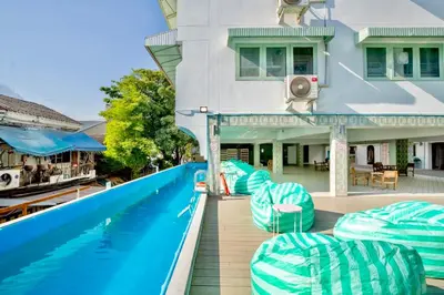 a house with a swimming pool next to a house at Capsule Hostel and Thai Traditional Bath Bangkok in Bangkok