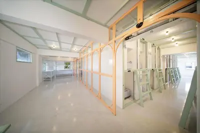 a room with a row of windows and chairs at Capsule Hostel and Thai Traditional Bath Bangkok in Bangkok