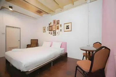 a bedroom with a bed and a table and a chair at Mitr Inn Yaowarat - เยาวราช Pro in Samphanthawong