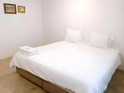 a white bed with white sheets and pillows on it at Mitr Inn Yaowarat - เยาวราช Pro in Samphanthawong