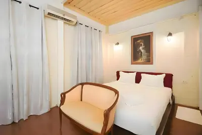 a bedroom with a white bed and a chair at Mitr Inn Yaowarat - เยาวราช Pro in Samphanthawong