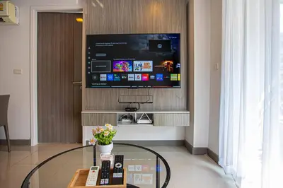 a living room with a tv and a glass table at Dazzle Residence ByPinny2 in Bangkok