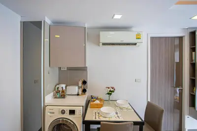 a small kitchen with a washing machine and a table at Dazzle Residence ByPinny2 in Bangkok