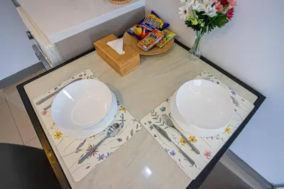 two white plates on a glass table in a kitchen at Dazzle Residence ByPinny2 in Bangkok