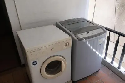 a washer and a washing machine next to a balcony at Big 3 bedroom apartment Asoke in Bangkok