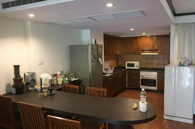a kitchen with a table and a refrigerator at Big 3 bedroom apartment Asoke in Bangkok