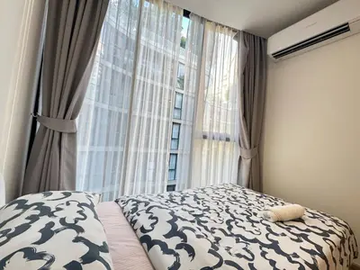 a bedroom with a bed and a large window at Fynn Bangkok Asoke Condo in Bangkok