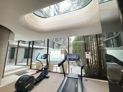 a gym with a treadmill in front of a window at Fynn Bangkok Asoke Condo in Bangkok