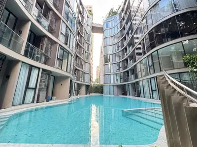a large swimming pool between two tall buildings at Fynn Bangkok Asoke Condo in Bangkok