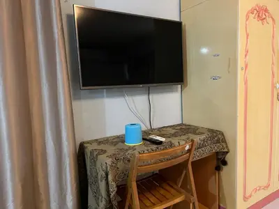 a table with a blue cup on a table with a television at Impact Arena C3 by Jintana in Ban Bang Phang