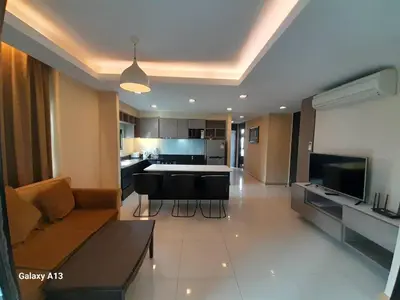 a large living room with a couch and a kitchen at Avatar Suites Hotel - SHA Extra Plus in Bangkok