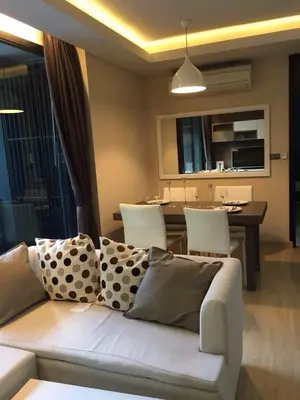 a living room with a couch and a dining room at Avatar Suites Hotel - SHA Extra Plus in Bangkok