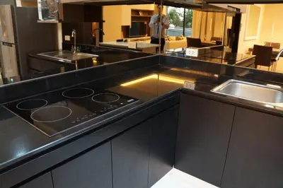 a kitchen with a black counter top with a sink at Avatar Suites Hotel - SHA Extra Plus in Bangkok
