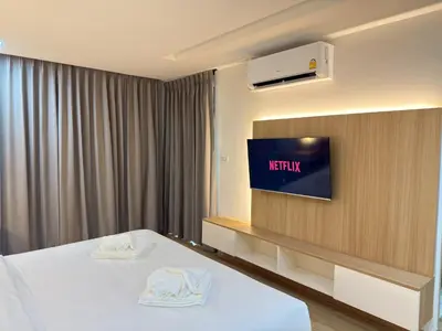 a hotel room with a bed and a flat screen tv at Armass Residence in Bangna