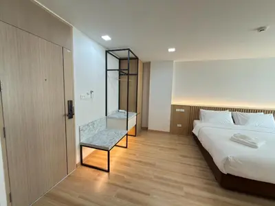 a bedroom with a bed and a glass shower at Armass Residence in Bangna