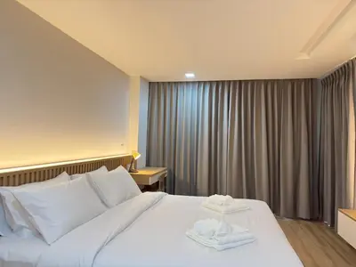 a hotel room with a bed with two towels on it at Armass Residence in Bangna