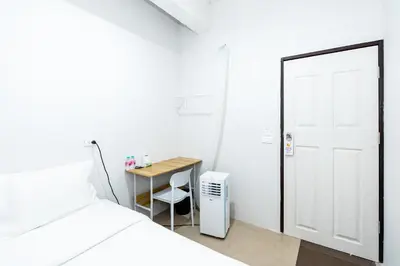a room with a bed and a desk and a door at xx The Hidden Khaosan in Bangkok