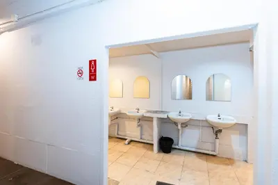 a bathroom with three sinks and two mirrors at xx The Hidden Khaosan in Bangkok