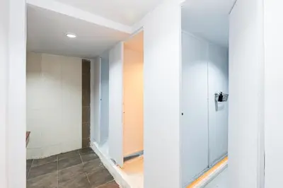 a bathroom with white walls and a walk in shower at xx The Hidden Khaosan in Bangkok