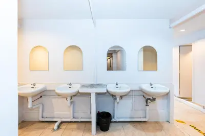 a bathroom with three sinks and two mirrors at xx The Hidden Khaosan in Bangkok