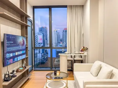 a living room with a white couch and a large window at Luxe City Condo in Central Bangkok in Pratunam