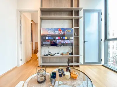 a living room with a glass table and a tv at Luxe City Condo in Central Bangkok in Pratunam
