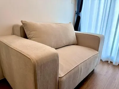 a couch with a pillow sitting in a living room at Bangkok Condo Ramkhamhaeng in Sathani Ban Hua Mak