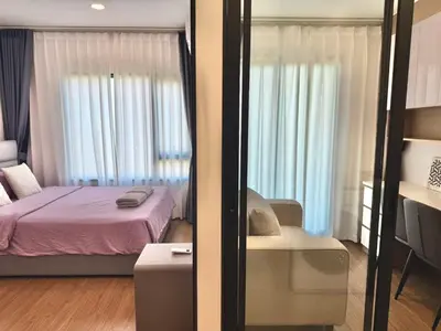 a bedroom with a bed and a chair in a room at Bangkok Condo Ramkhamhaeng in Sathani Ban Hua Mak