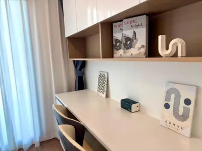a desk in a room with chairs and a book at Bangkok Condo Ramkhamhaeng in Sathani Ban Hua Mak
