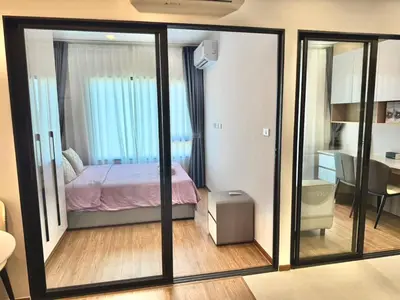 a room with a bedroom with a bed and a table at Bangkok Condo Ramkhamhaeng in Sathani Ban Hua Mak