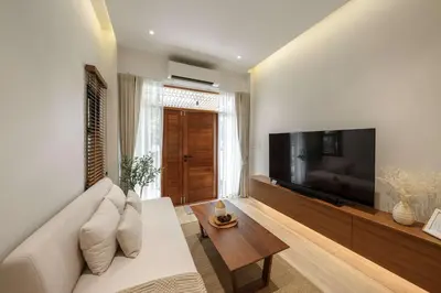 a living room with a white couch and a large television at Bhumidol Home near Don Muang Airport in Lak Si