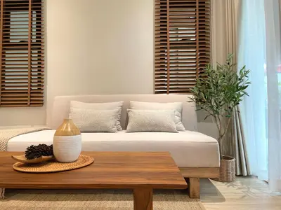 a living room with a bed and a coffee table at Bhumidol Home near Don Muang Airport in Lak Si