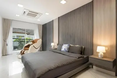 a bedroom with a bed and a chair and a window at Bangkoks most beautiful modern villa centre in Bangkok