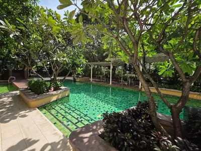 a swimming pool with green water in a garden at Chaophraya River high-rise river view apartment direct access to iconsiam Siam Square Chinatown 0 distance from BTS subway exit direct to Sathorn Silom Road Siam Square in Bangkok