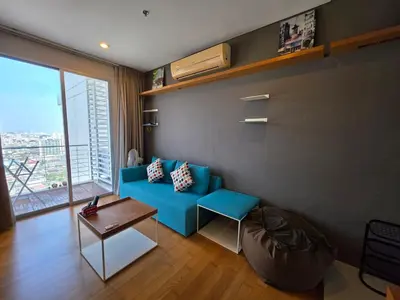 a living room with a blue couch and a table at Chaophraya River high-rise river view apartment direct access to iconsiam Siam Square Chinatown 0 distance from BTS subway exit direct to Sathorn Silom Road Siam Square in Bangkok