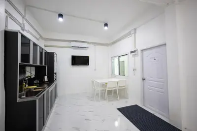 a white room with a table and a white door at ดอนเมือง 303 Near DMK Airport BTS Wat PhraSi in Bang Khen