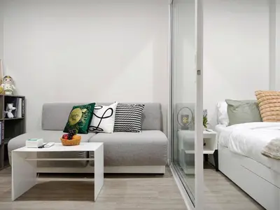 a living room with a bed and a couch and a table at Phahonyothin 35 Cozy 1BR Near BTS Chatuchak in Sathani Bang Khen
