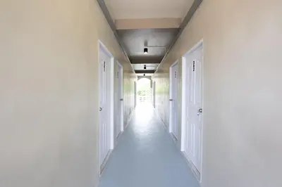 an empty hallway with white walls and white doors at ดอนเมือง 306 Near DMK Airport BTS Wat PhraSi in Bang Khen