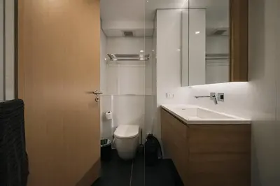 a bathroom with a sink and a toilet and a mirror at High-Ceiling Loft Suite Rama 9 Design Apartment in Bangkok