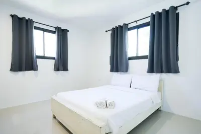 two wedding rings on a bed in a room with windows at Snap Sukhumvit 1 - Bangkok City