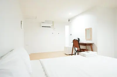 a white bedroom with a desk and a bed at Snap Sukhumvit 1 - Bangkok City