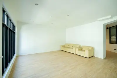 a living room with a couch and a wooden floor at Snap Sukhumvit 1 - Bangkok City
