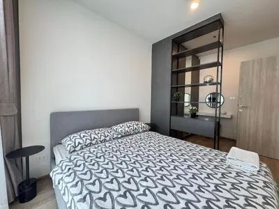 a bedroom with a bed with a black and white comforter at NUE District Rama 9 Condo in Bangkok