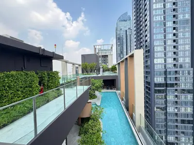 an apartment balcony with a swimming pool and tall buildings at NUE District Rama 9 Condo in Bangkok