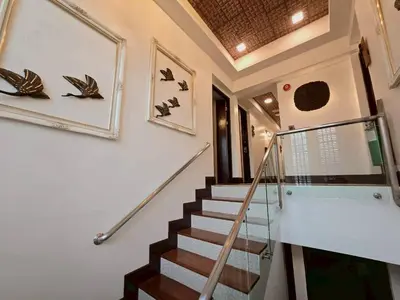 a staircase in a house with birds on the wall at Casa Le Damuz in Bangkok