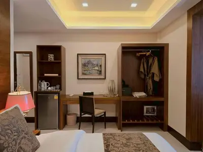 a bedroom with a bed and a desk with a chair at Casa Le Damuz in Bangkok