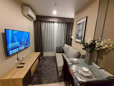 a living room with a couch and a table and a television at Idea Labs Luxury Condo Coworking spaces in Ban Khlong Samrong