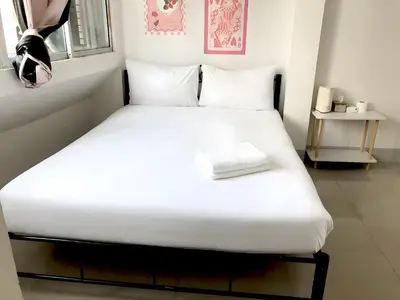a bedroom with a bed with white sheets and a window at Oh My Nap Sukhumvit Soi 3 - คลองเตยเหนือ in Makkasan